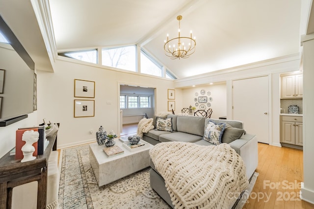 living room featuring vaulted ceiling with beams, light hardwood / wood-style flooring, and a chandelier