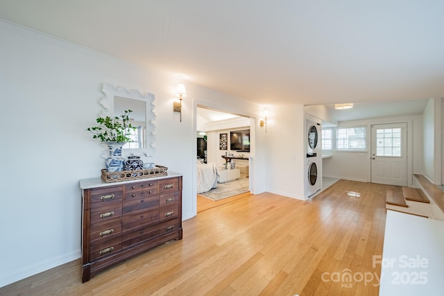 entrance foyer featuring light hardwood / wood-style flooring and stacked washer / dryer