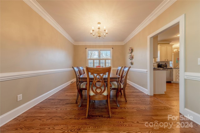 dining area featuring hardwood / wood-style floors, crown molding, and a notable chandelier