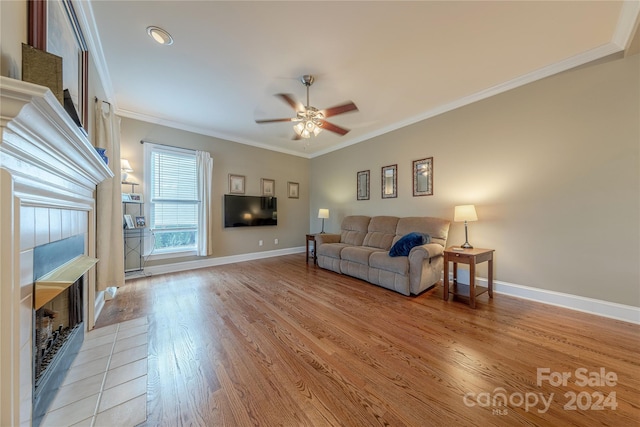 living room with ceiling fan, ornamental molding, and light hardwood / wood-style flooring