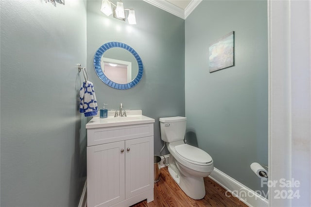 bathroom with crown molding, hardwood / wood-style floors, vanity, and toilet