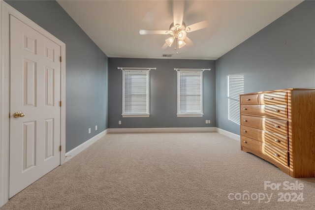 unfurnished bedroom with ceiling fan and light colored carpet