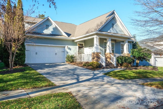 view of front of property with covered porch, a garage, and a front lawn