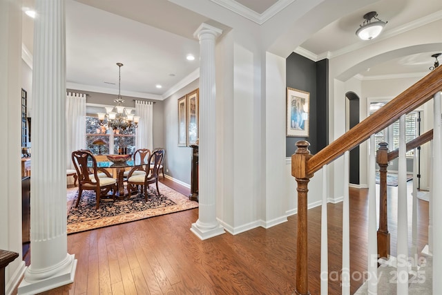 dining space with crown molding, dark hardwood / wood-style flooring, and an inviting chandelier