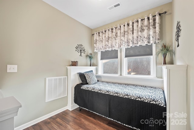 bedroom with multiple windows and dark wood-type flooring