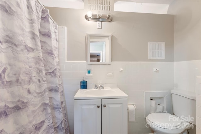 bathroom featuring a shower with shower curtain, vanity, toilet, and tile walls