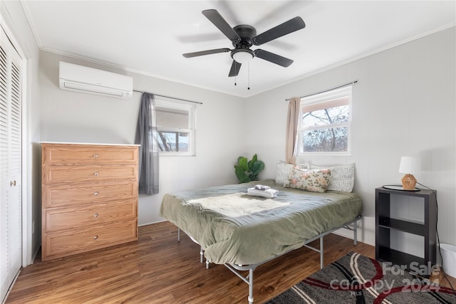 bedroom with ornamental molding, ceiling fan, hardwood / wood-style flooring, an AC wall unit, and a closet