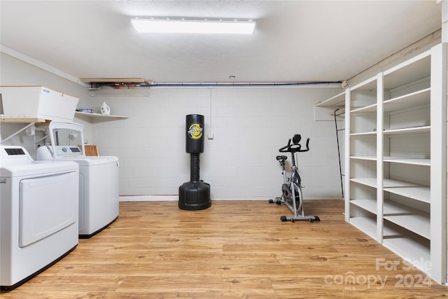 laundry area featuring washing machine and dryer and light wood-type flooring