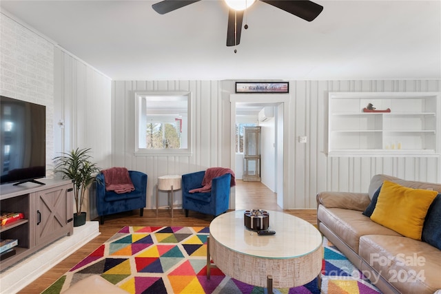 living room featuring ceiling fan, a wall mounted air conditioner, and hardwood / wood-style flooring