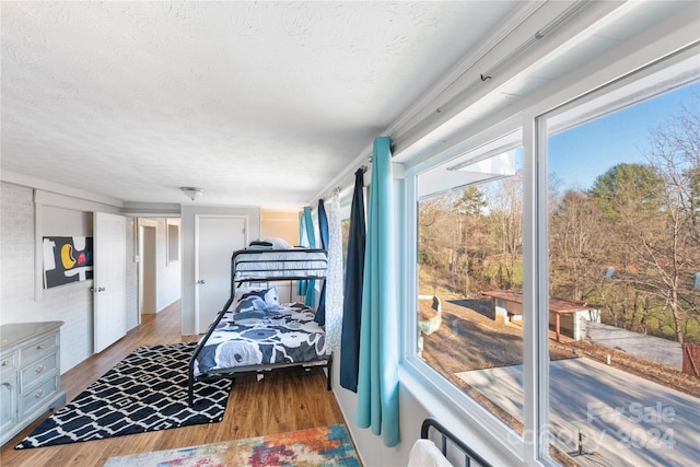 bedroom with hardwood / wood-style floors and a textured ceiling