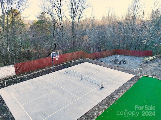 patio terrace at dusk featuring tennis court