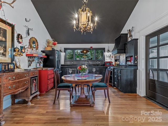 dining area featuring wood-type flooring, lofted ceiling, and a notable chandelier