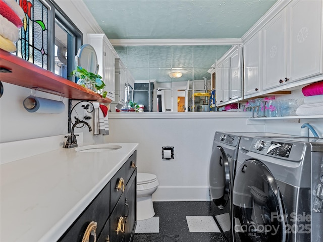 clothes washing area with separate washer and dryer, crown molding, and sink