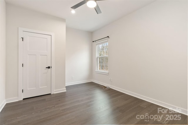 spare room with dark wood-type flooring and ceiling fan