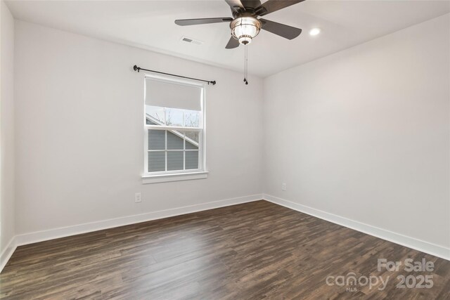 spare room featuring dark wood-type flooring and ceiling fan