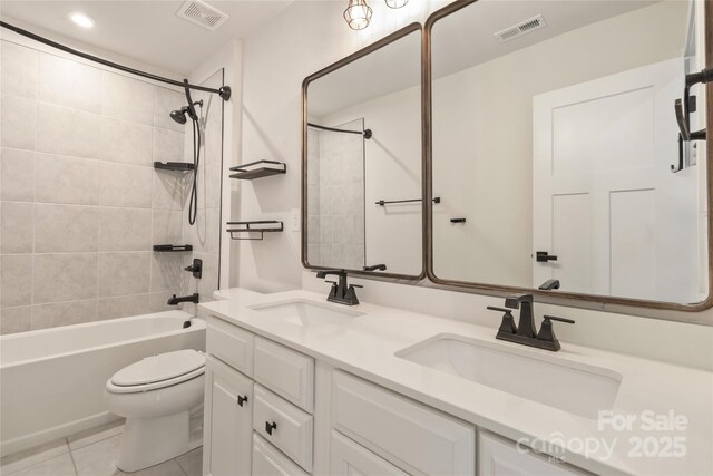 full bathroom featuring tiled shower / bath, tile patterned floors, toilet, and vanity