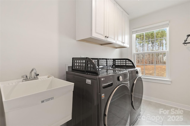 laundry area with cabinets, sink, light tile patterned floors, and washer and clothes dryer