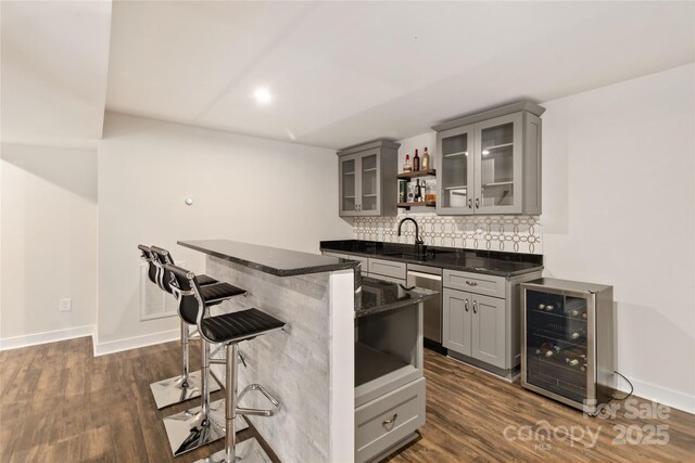 bar with wine cooler, sink, gray cabinets, and stainless steel dishwasher