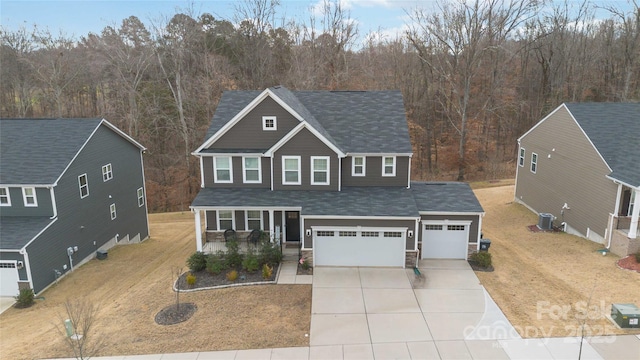 view of front of home featuring a garage, cooling unit, covered porch, and a front lawn