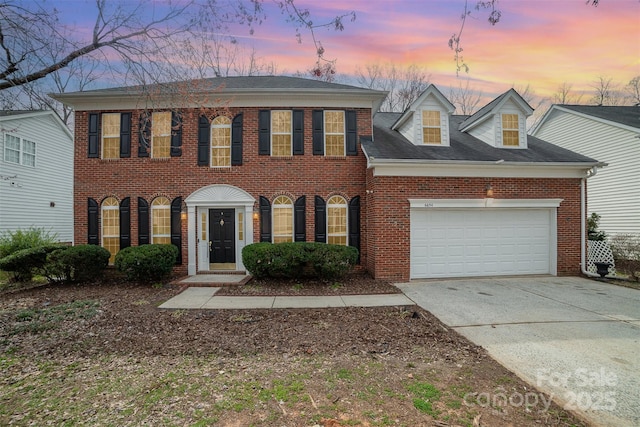 view of front facade featuring an attached garage, brick siding, and driveway