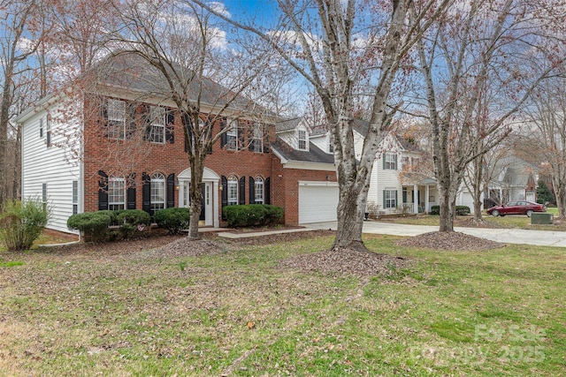 view of front of home with brick siding, driveway, an attached garage, and a front lawn