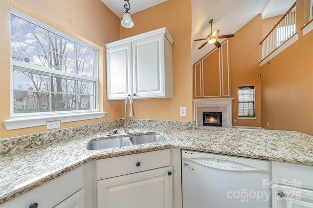 kitchen featuring a sink, white cabinetry, a ceiling fan, and white dishwasher