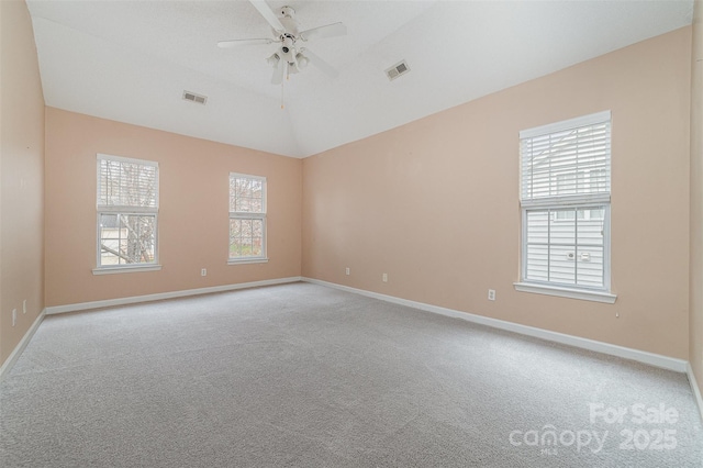 spare room featuring visible vents, lofted ceiling, light carpet, and ceiling fan