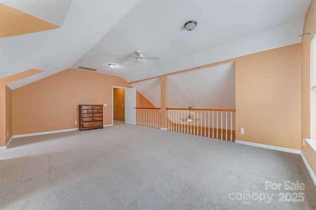 additional living space with baseboards, visible vents, lofted ceiling, ceiling fan, and carpet flooring