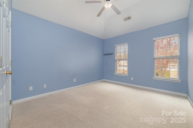 carpeted spare room featuring visible vents, lofted ceiling, baseboards, and a ceiling fan