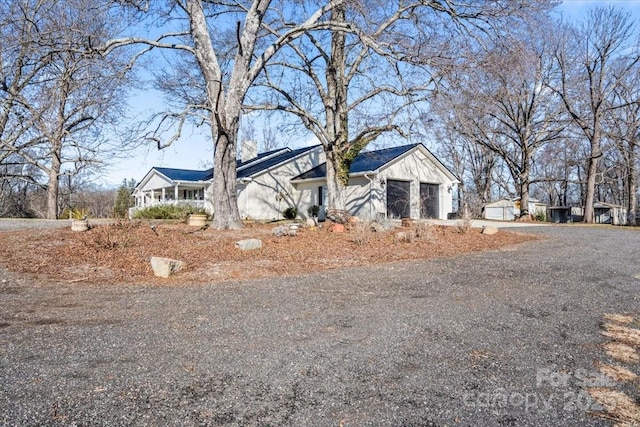 ranch-style home featuring a porch and a garage