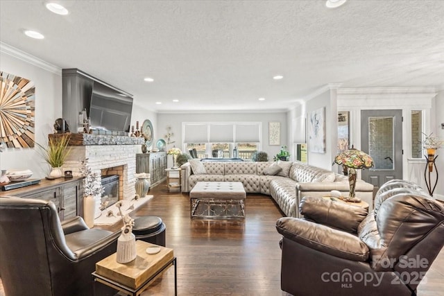 living room with a stone fireplace, dark hardwood / wood-style flooring, a textured ceiling, and ornamental molding