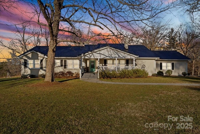 single story home featuring a lawn and covered porch