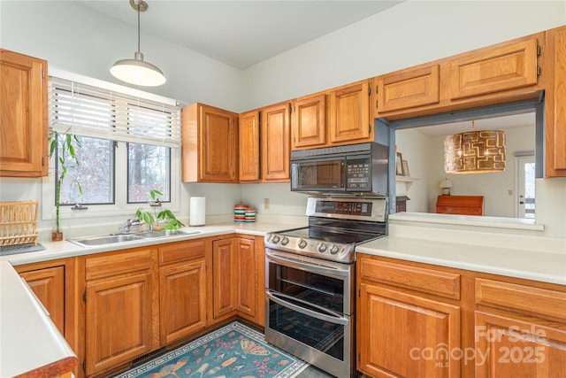 kitchen featuring sink, range with two ovens, and pendant lighting