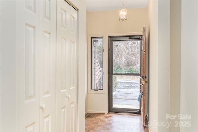 doorway to outside featuring light parquet flooring