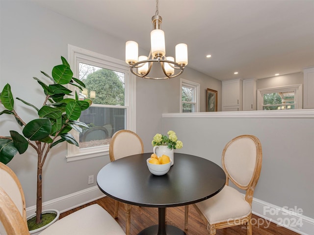 dining area with wood-type flooring and a notable chandelier