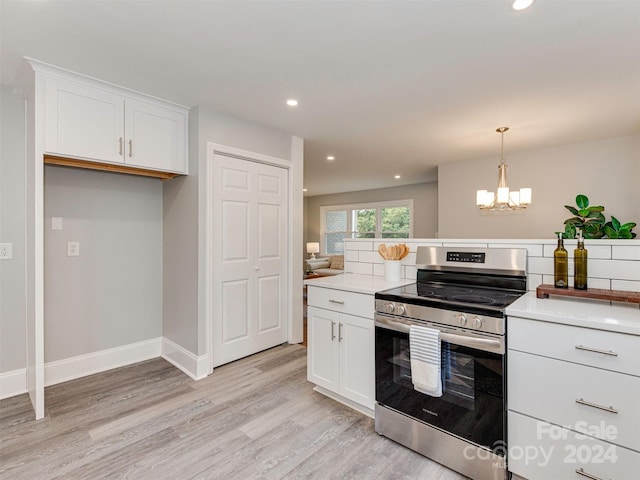 kitchen featuring pendant lighting, light hardwood / wood-style flooring, stainless steel range oven, a chandelier, and white cabinetry