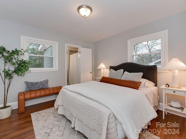 bedroom with multiple windows and hardwood / wood-style floors