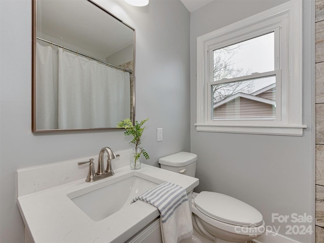 bathroom with a shower with curtain, vanity, and toilet