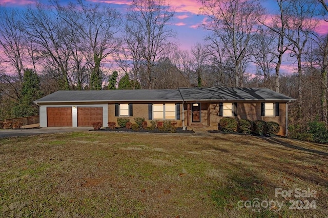 ranch-style home with a lawn and a garage