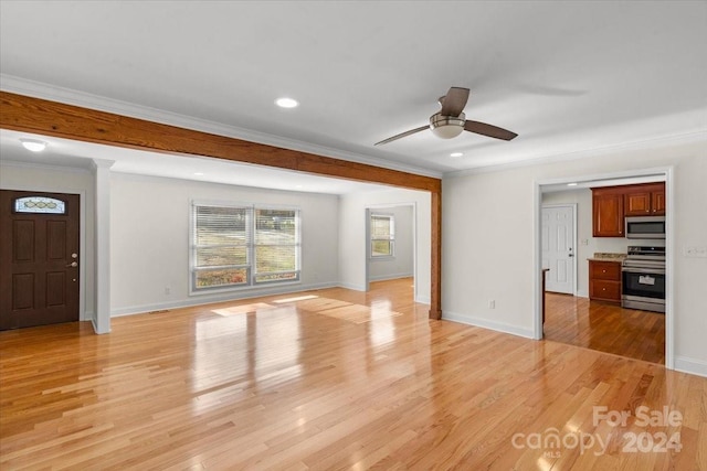 unfurnished living room featuring light hardwood / wood-style floors, ceiling fan, and ornamental molding