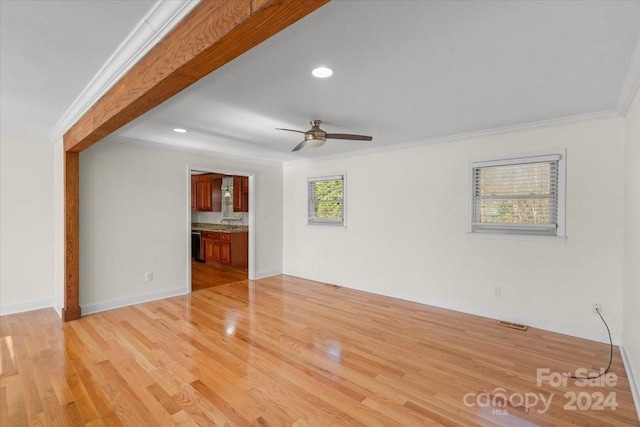 unfurnished living room featuring ceiling fan, light wood-type flooring, and ornamental molding