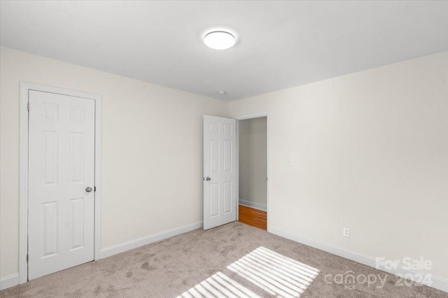 unfurnished room with light carpet