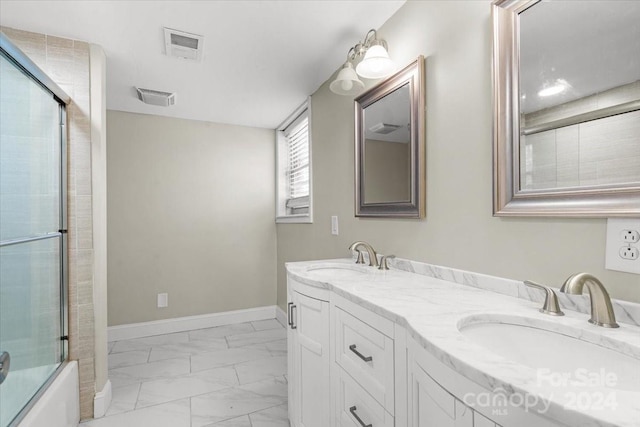 bathroom featuring vanity and bath / shower combo with glass door