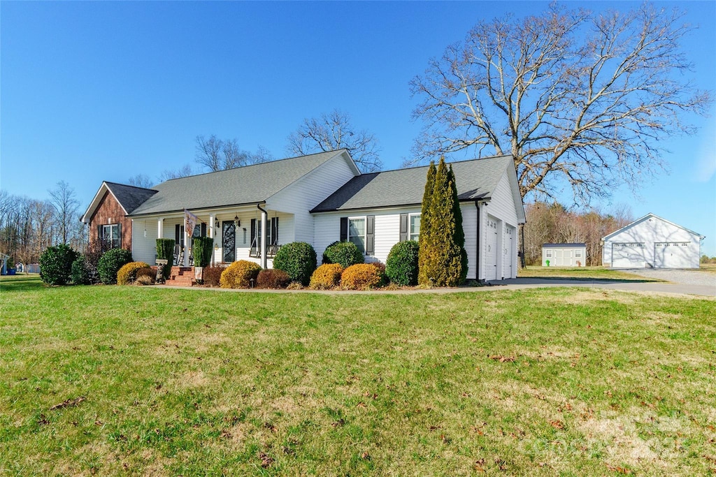 view of front facade featuring a front lawn, covered porch, and a garage