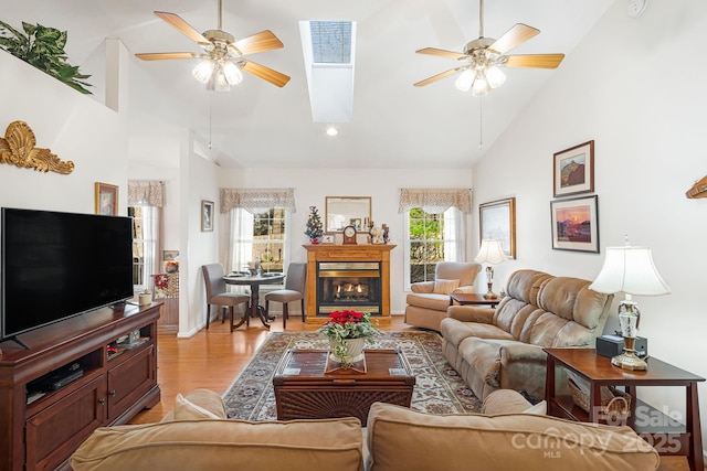 living room featuring ceiling fan, light hardwood / wood-style flooring, and high vaulted ceiling