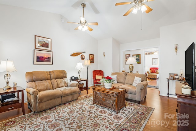 living room with ceiling fan, vaulted ceiling, and light wood-type flooring