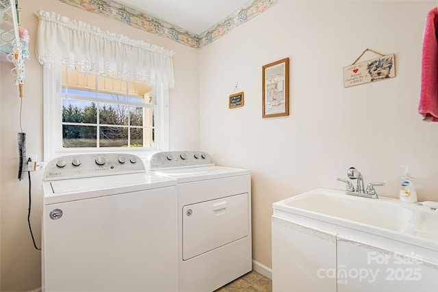 clothes washing area featuring washer and dryer, light tile patterned floors, and sink