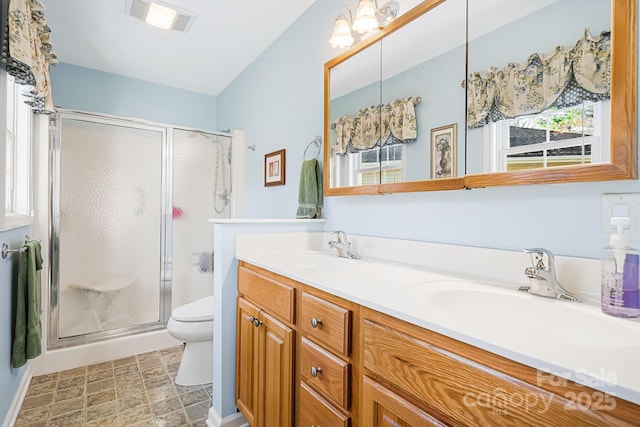 bathroom featuring vanity, toilet, and walk in shower