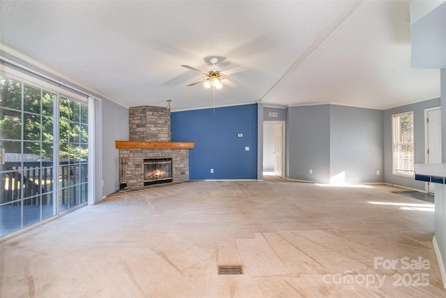 unfurnished living room with ceiling fan, a fireplace, carpet floors, and crown molding