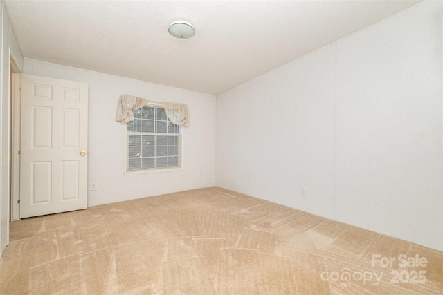 unfurnished room featuring light carpet